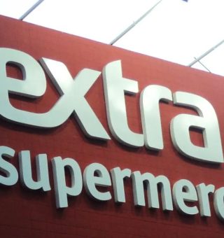 Frente de supermercado Extra com grande letreiro em branco sobre o fundo vermelho