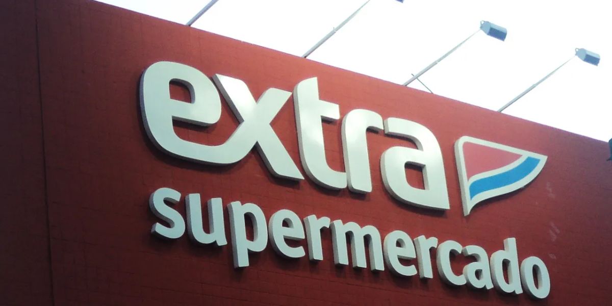 Frente de supermercado Extra com grande letreiro em branco sobre o fundo vermelho