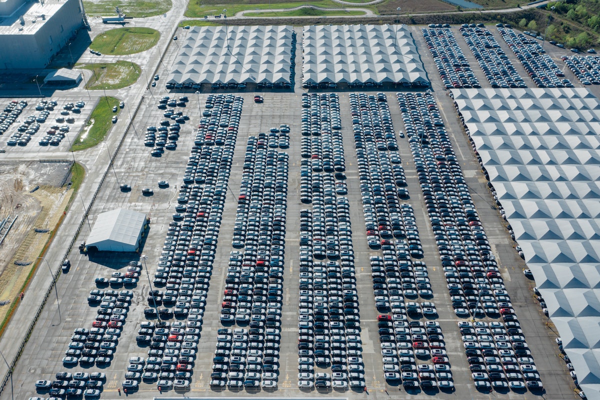 Vista aérea de um pátio da Ford com centenas de carros estacionados 