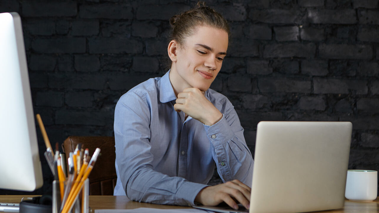 Adolescente trabalhando em escritório em frente ao Notebook como menor aprendiz Caixa 2024