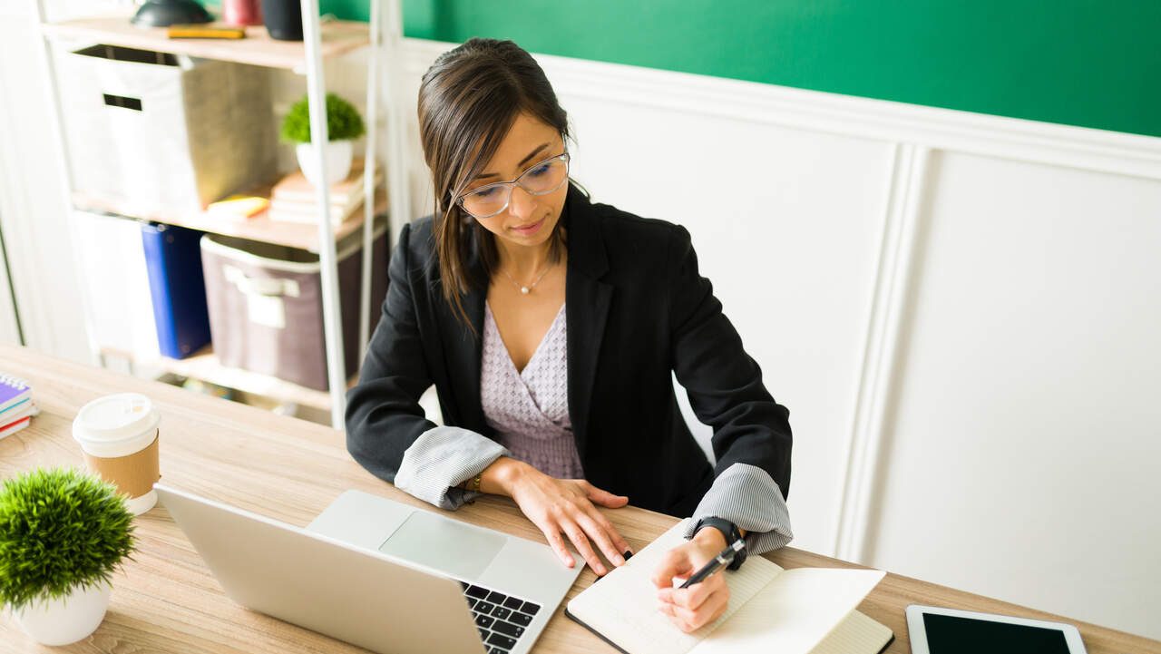 Mulher trabalhando com Notebook em escritório como Jovem Aprendiz IMPA 2024